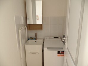 A compact bathroom with a sink, mirror, and a small heater unit. - A Picciridda by Wonderful Italy (Syracuse)