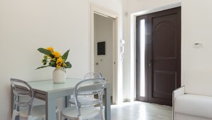 A dining area with a table, chairs, and a vase of flowers. - Villetta Silvana by Wonderful Italy (Ostuni)