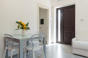 Un comedor con una mesa, sillas y un florero.