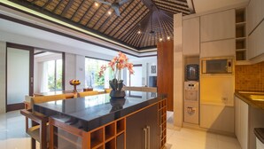 A modern kitchen with a central island, built-in microwave, and a water dispenser. - Rekso Villa·Seaside Serenity,Elegant Escape, Beach (Unit 2009)