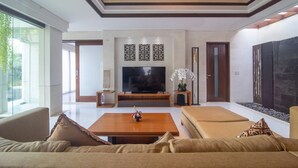 A modern living room with a flat-screen TV, a wooden coffee table, and a sofa. - Rekso Villa·Seaside Serenity,Elegant Escape, Beach (Unit 2009)