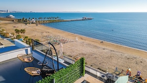 A beachside hotel with a pool area, outdoor seating, and a view of the sea and a pier. - The Ultimate Jacuzzi Penthouse by PS (Durrës)