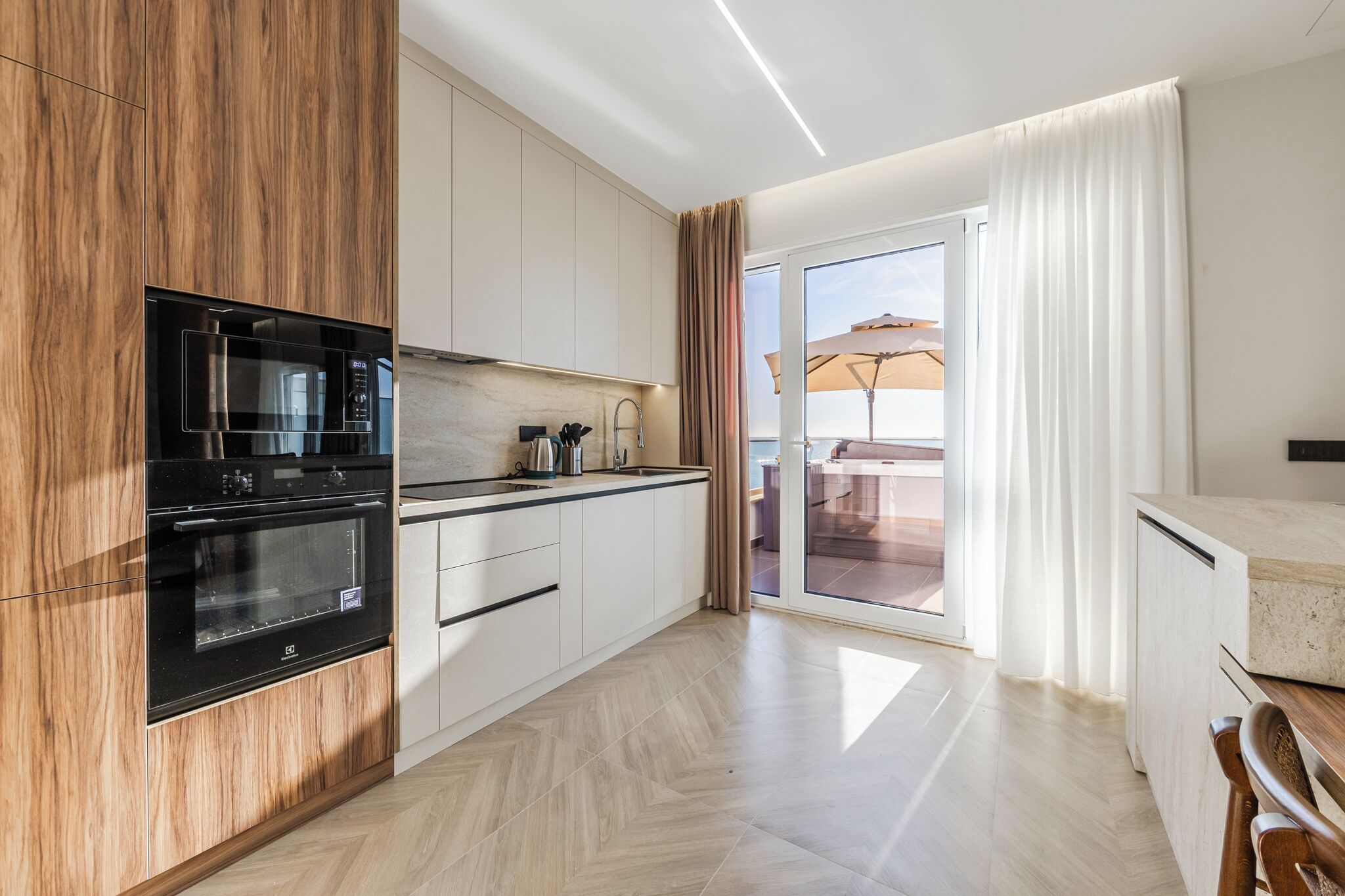Una cocina moderna con horno empotrado, microondas y lavamanos.
