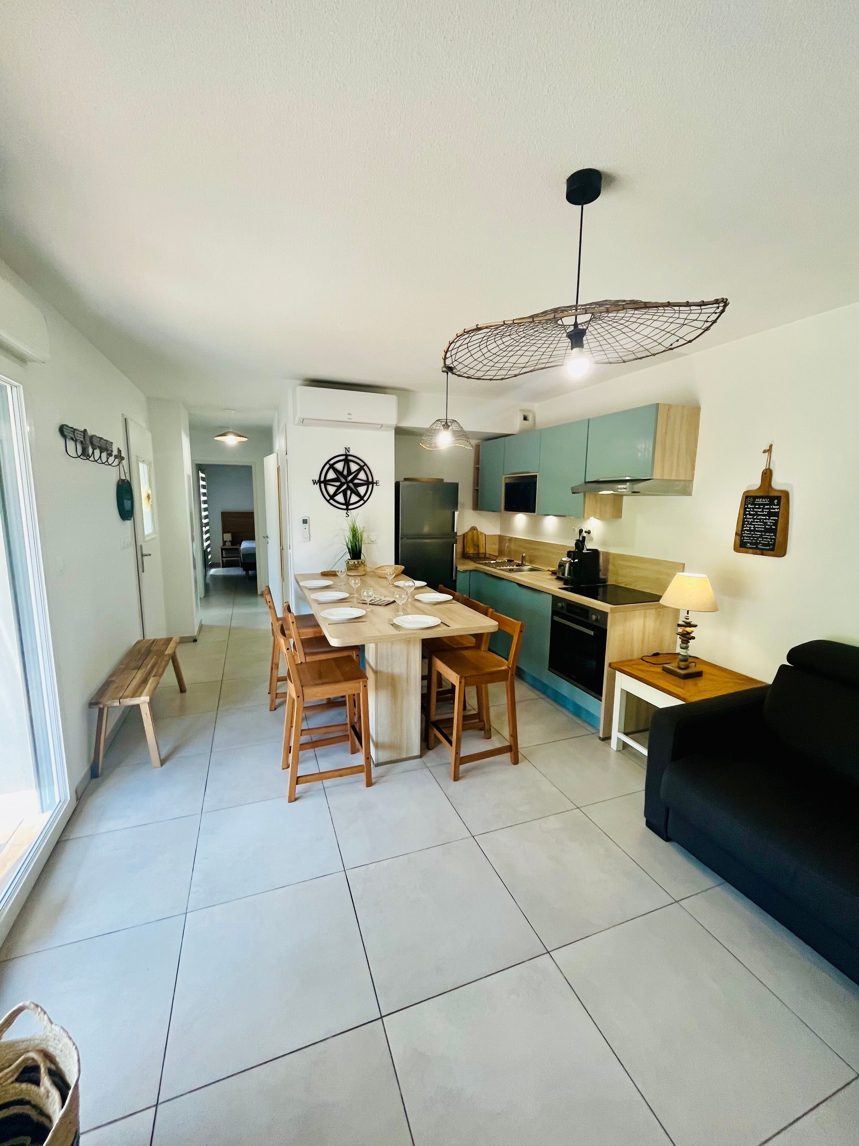 A modern kitchen with a central island, wooden chairs, and a dining table set for six. - V0755-Villa sleeps 6 in residence with communal pool close to the sea (Vias)