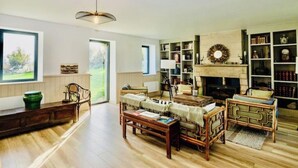 Ein geräumiges Wohnzimmer mit Kamin, Holzmöbeln und Bücherregal.
