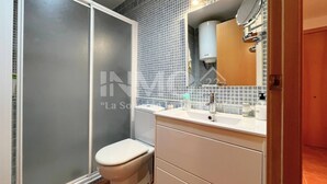 Ein Badezimmer mit Toilette, Waschbecken und Spiegel.