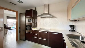 Eine moderne Küche mit Kochinsel, integriertem Backofen und Edelstahlgeräten.