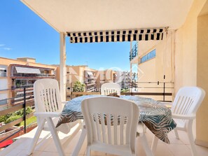 A balcony with a table and chairs, overlooking a residential area. - Apartamento en 1ra linea (Cambrils)