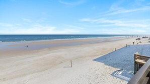 Una playa con una terraza de madera que da al océano.