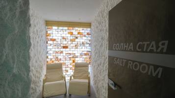 Una sala de sal con dos sillones y una pared con diseño de sal.
