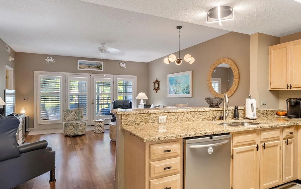 A modern kitchen with granite countertops, wooden cabinets, and a built-in dishwasher.