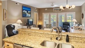 Eine moderne Küche mit Granit-Arbeitsplatten, Spüle aus Edelstahl und einem Essbereich mit Tisch und Stühlen.