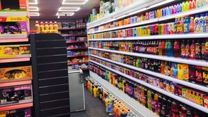 A grocery store aisle with shelves stocked with various beverages and snacks.