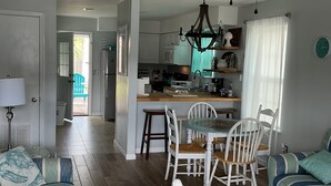 Ein geräumiges Wohnzimmer mit Essbereich, einer Küche und Blick ins Freie.