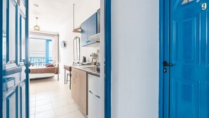 Uma cozinha com porta azul, geladeira branca e armários de madeira.