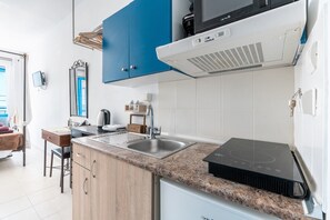 Een moderne keuken met een ingebouwde magnetron, fornuis en spoelbak.
