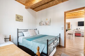 A bedroom with a bed, a desk, and a chair.