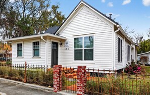 A two-story house with a gabled roof, a front porch, and a brick entryway.