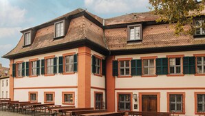 A building with multiple windows and a courtyard with outdoor seating. - HOY bamberg boutique hotel (Bamberg)