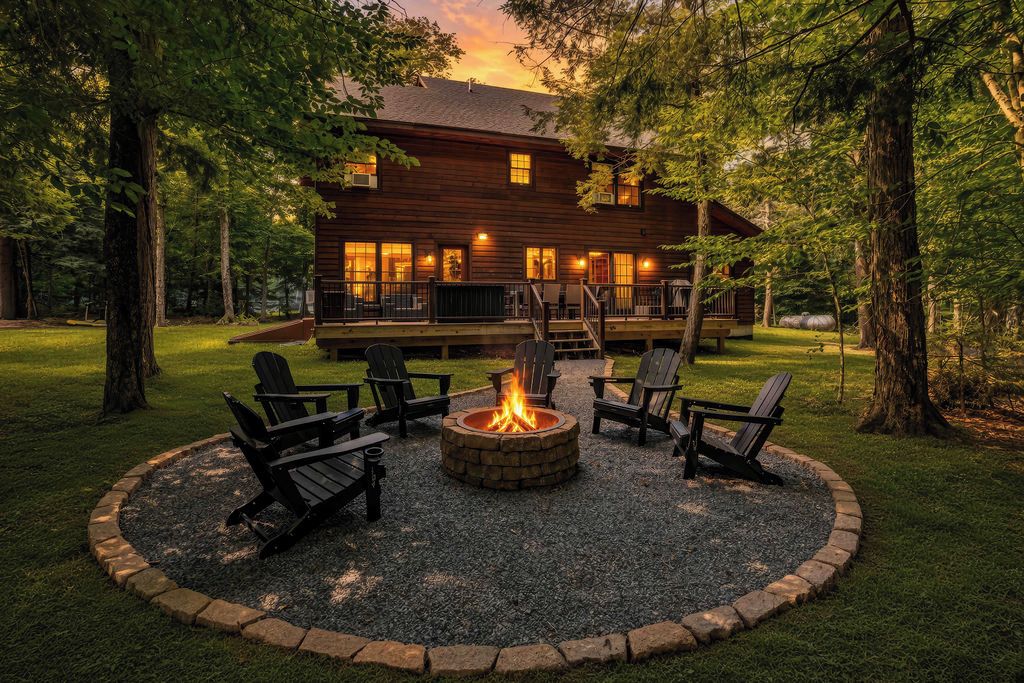 A wooden cabin with a fire pit and outdoor seating.