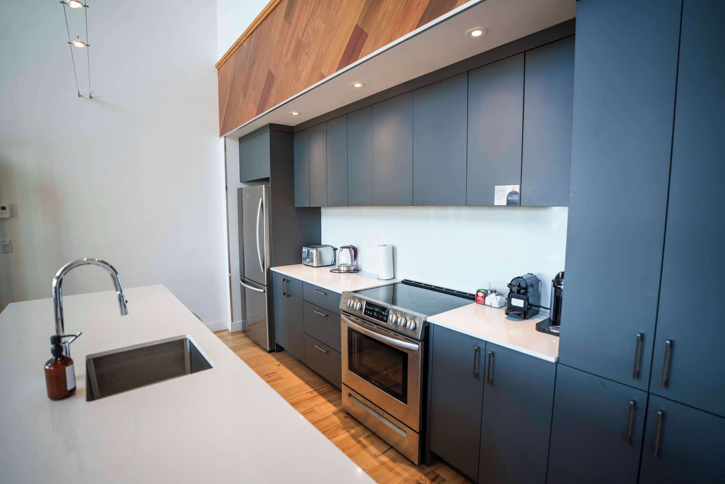 Una cucina moderna con forno in acciaio inossidabile, lavello incassato e pensili in legno.