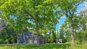 A pathway leading to a rustic cabin surrounded by lush greenery and trees.