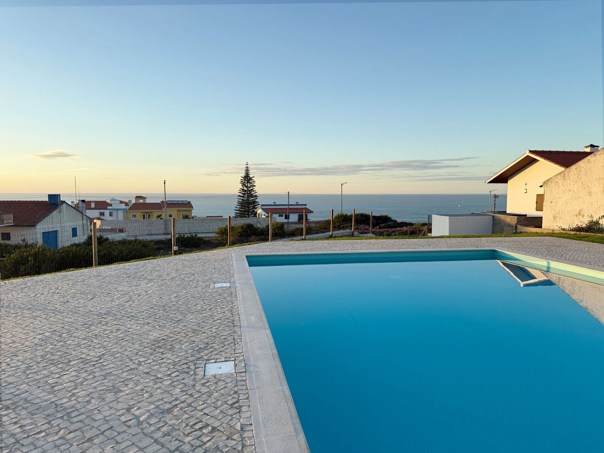 Une piscine offrant une vue dégagée sur la mer et sur les bâtiments qui se dressent à l’arrière-plan.