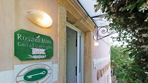 A building entrance with a green sign for 'Rosadi Mare Gorra Finale Ligure Rooms' and a key-shaped emblem for 'AFFITTACAMERE.' - 'Peperoncino' Room with Hill View (finale ligure)
