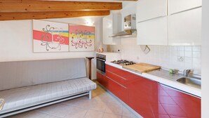 A kitchen with a built-in bench, a stove, and a sink. - 'Peperoncino' Room with Hill View (finale ligure)