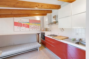 Una cocina con banco integrado, estufa y pileta.