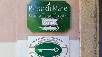 Un cartel con la inscripción 'Rosadi Mare' y 'Gorra Finale Ligure' que indica un lugar.