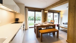 Een moderne keuken met een eethoek, houten balken en grote ramen.