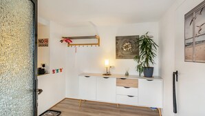 Una habitación moderna con un armario blanco, una lámpara, una planta y un cartel que indica 'NO FUMAR'.