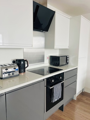 A modern kitchen with a built-in microwave, toaster, and oven. - 20% Discount, 1-Bed Apartment  Maidstone Town Centre, Free parking, Convenient (Maidtsone)