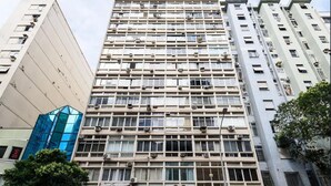 Un immeuble à plusieurs étages, doté d’une façade à motifs géométriques, de climatiseurs et d’une variété de styles de fenêtres.