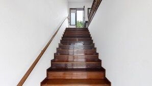 A wooden staircase with a handrail, leading to a door at the top. - Casa São Domingos Lousada – Conforto e Vista Deslumbrante para a Vossa Família (Lousada)