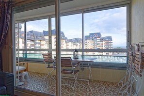 Ein Balkon mit Blick auf andere Gebäude, einem Tisch und zwei Stühlen.