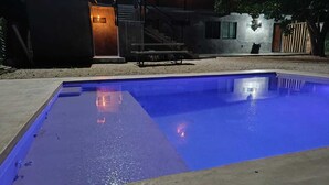 Piscina retangular com interior azul, rodeada por um deck de concreto.