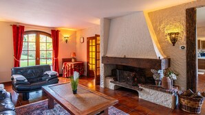 Un salon chaleureux avec une cheminée, un canapé en cuir et une table à manger.