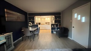 A modern living room with a dining area, a kitchen in the background, and a large window. - The Resorts World Retreat Spacious 4-bedroom house in beautiful Monticello (Monticello)