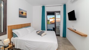 Une chambre d’hôtel avec un lit, une télévision, une fenêtre avec des rideaux et une vue sur l’extérieur.