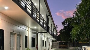 A modern two-story building with a flat roof, a covered walkway, and a well-maintained lawn. - CHURROS (La Libertad)