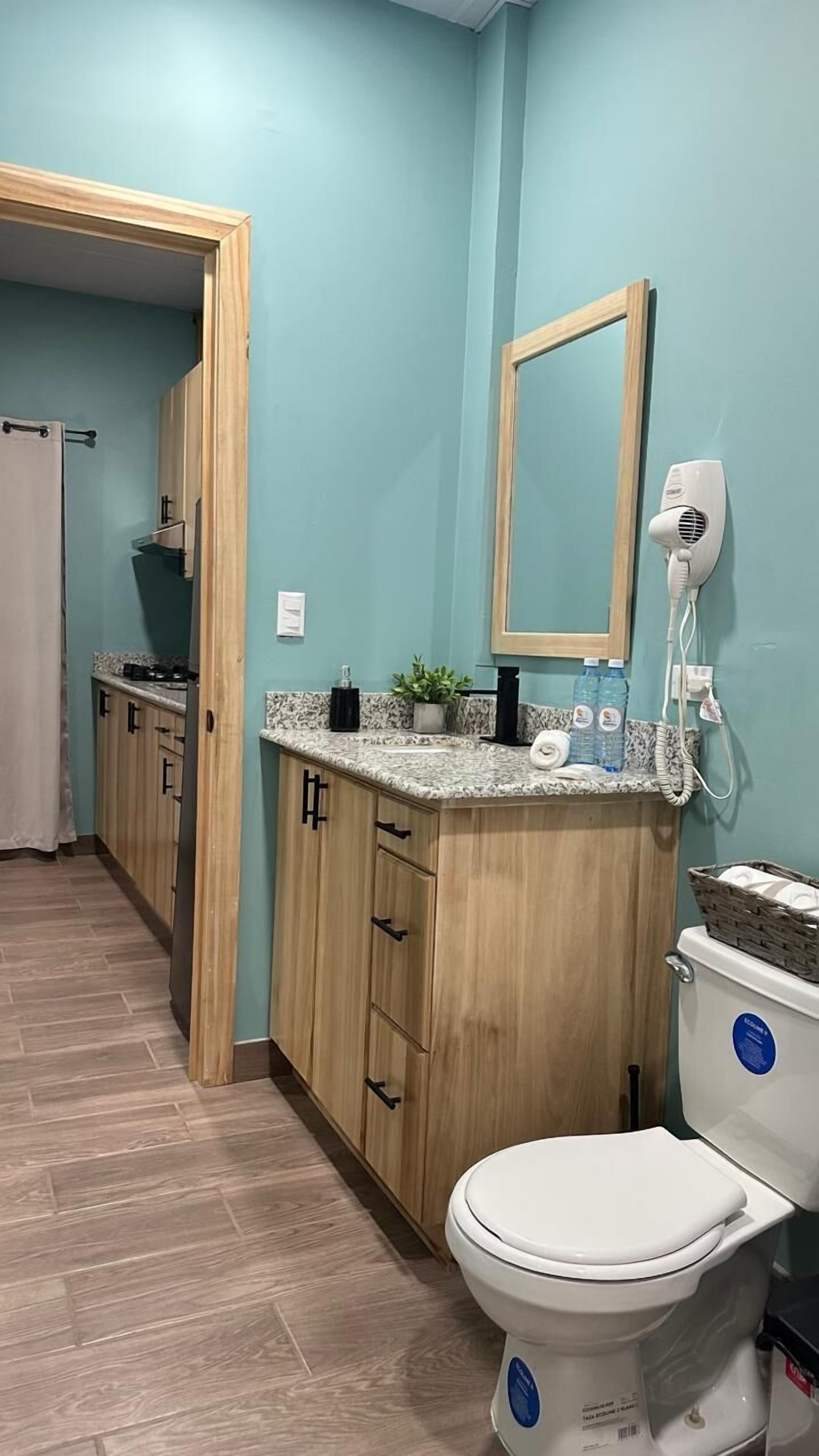 A modern bathroom with a toilet, sink, and mirror.