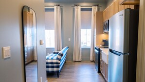 Una cocina compacta con refrigerador, microondas y armarios de madera.
