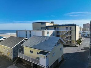 Un immeuble situé en bord de mer, avec plusieurs étages, des balcons et une vue sur l’océan.