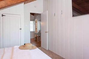 Une chambre à coucher avec un lit, un chapeau et une armoire.