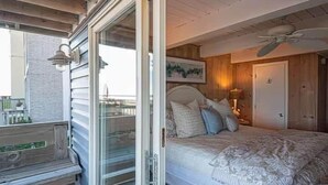 Un dormitorio con una cama, una mesita de noche, una lámpara y un cuadro en la pared.