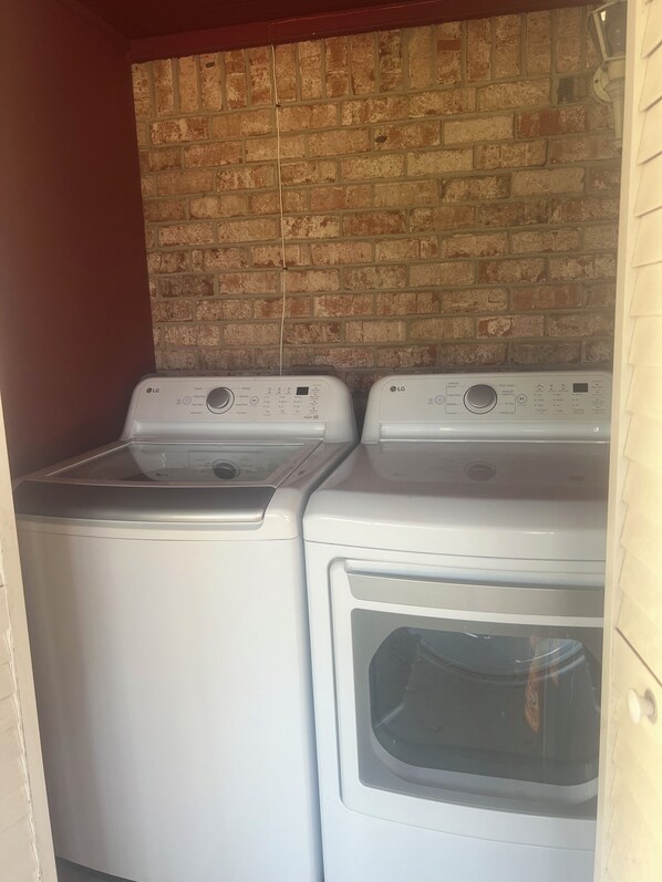 A laundry room with two white LG washing machines and a brick wall. - 3-bedroom house in gorgeous Pasadena with cool AC breeze (Pasadena)