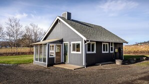 A small, single-story building with a sloped roof, a front porch, and a large sliding glass door. - bbbbbnnbbb (Medford)