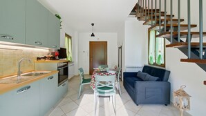 Un espacio habitable compacto con cocina, comedor y sofá.